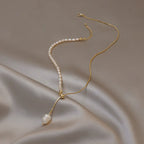 Pearl necklace with 14k gold chain on a beige fabric background