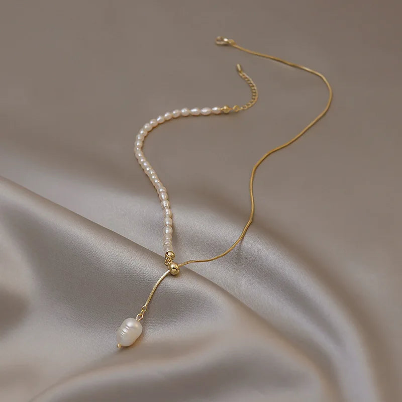 Pearl necklace with 14k gold chain on a beige fabric background